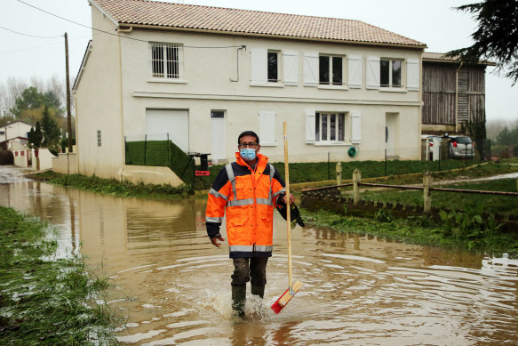 A volunteer on a flooded road in Coussan, near Marmande, south- western France. The worst flooding in 40 years swelled the Garonne River between Bordeaux and Toulouse in February turning orchards and vineyards into lakes. 