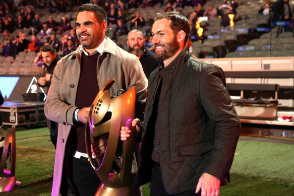 Greg Inglis and Dallas Johnson carry out a replica of the 2009 premiership trophy that the NRL stripped from the Storm.