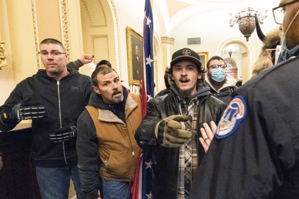 Violent protesters loyal to President Donald Trump are confronted by US Capitol Police officers outside the Senate Chamber inside the Capitol, during the riots. 