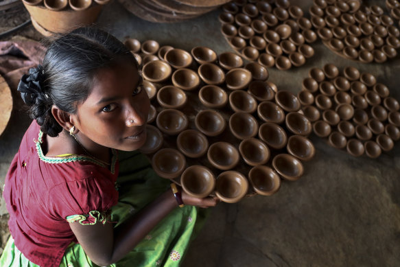 An Indian potter girl with earthen lamps for Diwali in Hyderabad, India.