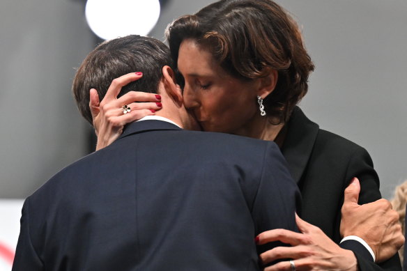 French President Emmanuel Macron and Sports Minister Ameie Oudea-Castera embrace at the Olympic opening ceremony.