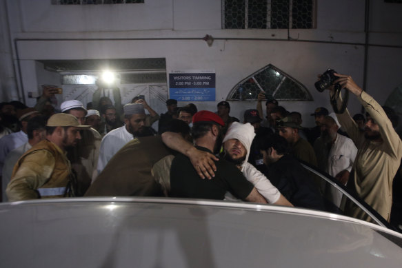 An injured victim of a powerful bomb hugs his relative after arriving at a hospital in Peshawar, Pakistan.