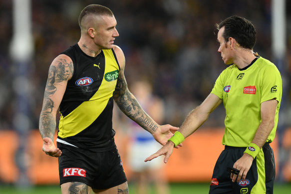 A wired-up umpire explains a decision to Dustin Martin.