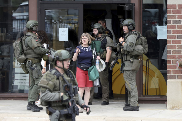 Law enforcement officers help evacuate the neighbourhood after the shooting in the Chicago suburb of Highland Park.