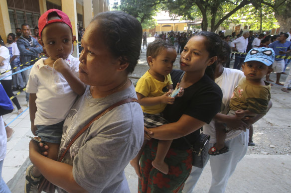 People queue up to cast their votes at a polling station in Dili.