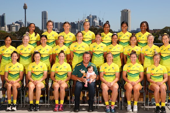 The Australian women's sevens team, with Emilee Cherry's daughter Alice sitting on the coach's knee.
