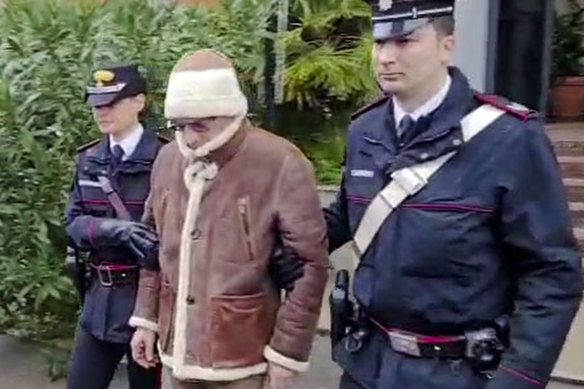 Top mafia boss Matteo Messina Denaro, center, leaves an Italian Carabinieri barracks shortly after his arrest at a private clinic in Palermo, Sicily.