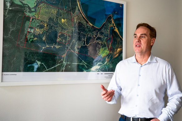 Mike Milliken of the Lyon Group in his office in front of a map of Boydtown. 