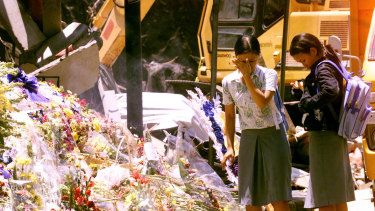 Indonesian students place flowers at the bomb blast area in Kuta on October 17, 2002.