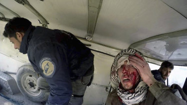An injured man sits in a White Helmets van after airstrikes hit near Ghouta on Wednesday. 