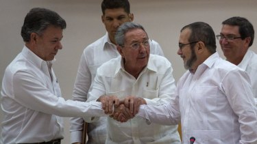 Cuban President Raul Castro, center, encourages Colombian President Juan Manuel Santos, left, and then FARC Commander Rodrigo Londono to shake hands after the signing of the peace accord in 2015.