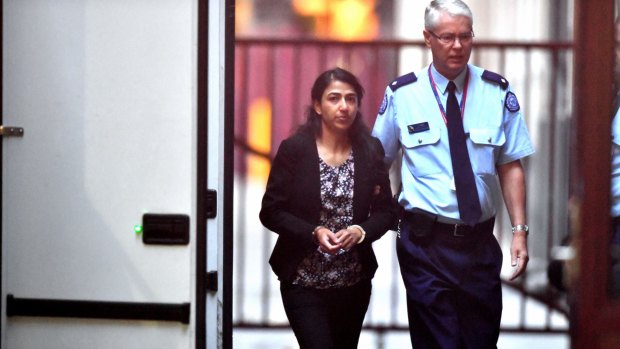 Sofia Sam is led into court by a prison guard to face the trial. 