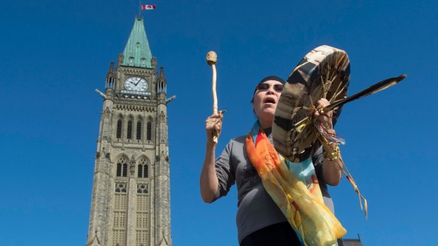 Marcia Brown Martel sings outside Canada's parliament  in October following the announcement of  compensation for  victims of  the "Sixties Scoop", during which Indigenous Canadians were taken from their homes and adopted into non-Indigenous families.
