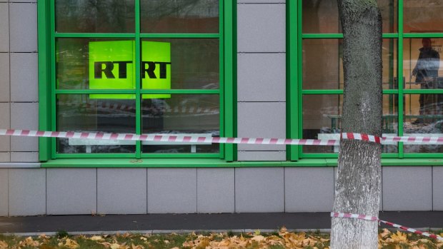 Russian state-owned television station RT logo is seen at the window of the company's office in Moscow.