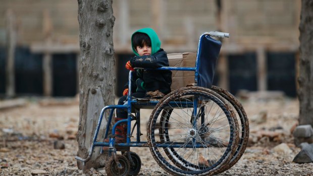 A Syrian child sits on a wheelchair after he and his family crossed into Turkey at the Oncupinar border crossing with Syria.