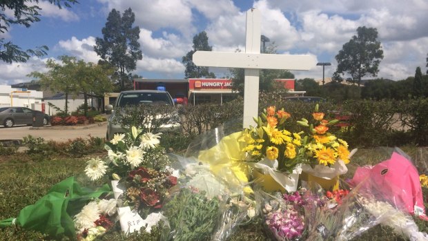 Flowers laid outside Hungry Jack's in Hoxton Park, where Courtney Topic was shot dead. 