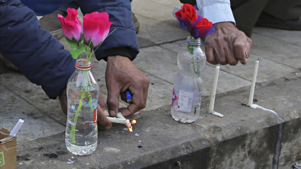 People light candles at the site of twin suicide bombings in Baghdad. 