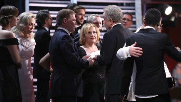 Faye Dunaway, from left, accountant Brian Cullinan, AMPAS staffer, and Warren Beatty discuss the result of best picture at the Oscars.
