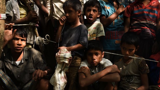 Rohingya refugee children wait at a Red Cross distribution point in Burma Para refugee camp.