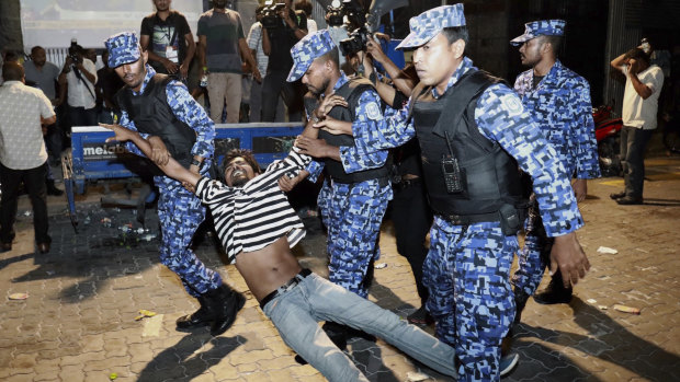 Maldivian police officers detain an opposition protester demanding the release of political prisoners during a protest in Male, Maldives. 