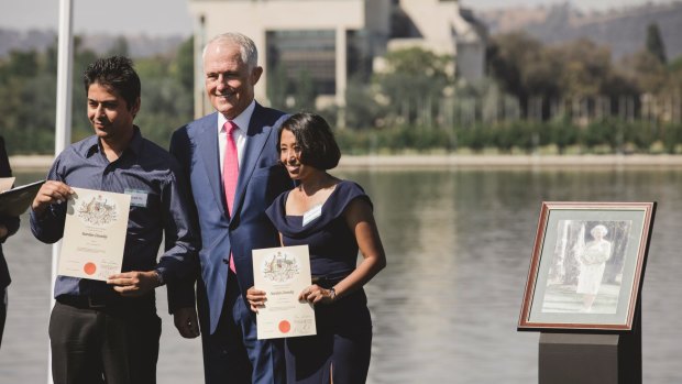 Prime Minister Malcolm Turnbull presents citizenship certificates in Canberra. 