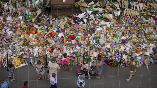 People lay flowers at the memorial to the victims of the Bourke Street attack.