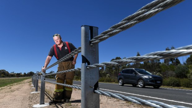 Captain Andy Chapman from Elphinstone CFA next to wire barriers on the Calder Freeway.