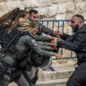 Members of the Israeli security forces scuffle with a Palestinian man at a checkpoint near Lion’s Gate to enter the Al-Aqsa Mosque compound before the Friday noon prayer in Jerusalem.