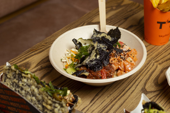 Taco bowl with brown rice, sashimi salmon, jackfruit, pickled cucumber and salsa roja.