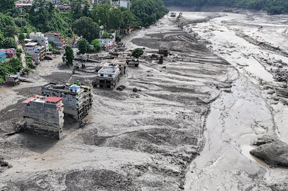 An aerial view shows buildings and infrastructure damaged along the swollen Trishuli River following a massive flash flood triggered by an avalanche of ice and rock in the upper Lhende River on the Tibetan side of the border with Nepal.