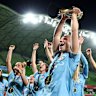 Holly McNamara and her teammates celebrate with the trophy.