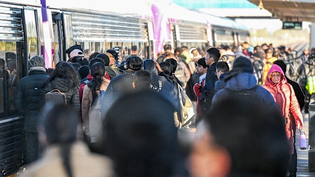 Commuters wait on the platform during the morning peak hour at Tarneit train station.