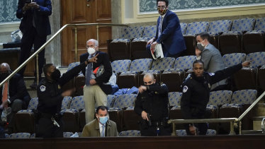 US legislators prepare to evacuate the House gallery as protesters try to break into the chamber during the US Capitol riots last week.