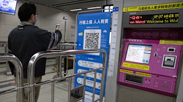 A commuter in Wuhan scans his health pass for the all-clear to ride the metro system.