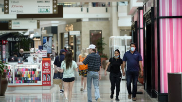 Even after re-opening the public has hesitated. Some shoppers wear masks as they walk through a mall in Woodlands, Texas.