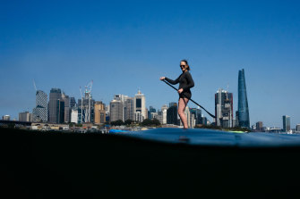 Steph Kelly tests out her new inflatable paddleboard for the first time, in Sydney Harbour, near Waverton. 