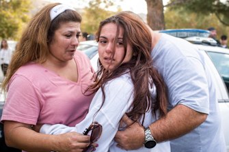 Keegan Burns, 16, seeks the comfort of her parents Mirasol and Jim following the shooting at Santa Clarita.