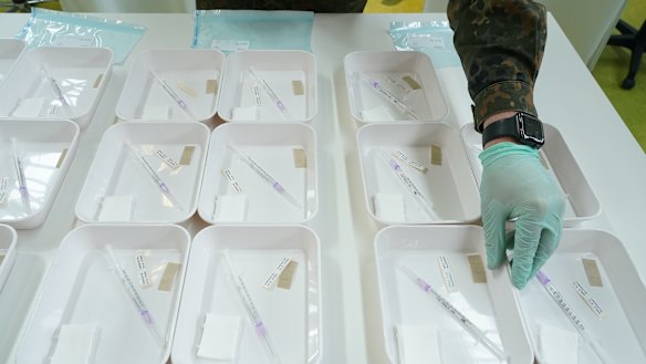 A member of the German army assists in preparing trays of syringes filled with the Pfizer/BioNTech vaccine against COVID-19 at the Arena Berlin mass vaccination centre. 