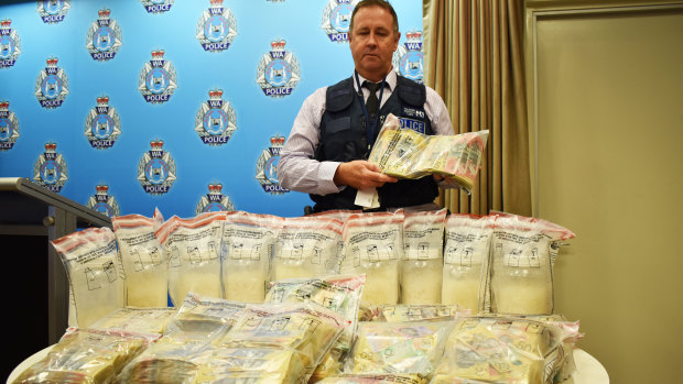 Detective Sergeant Paul Schubert with some of the seized drugs and cash.