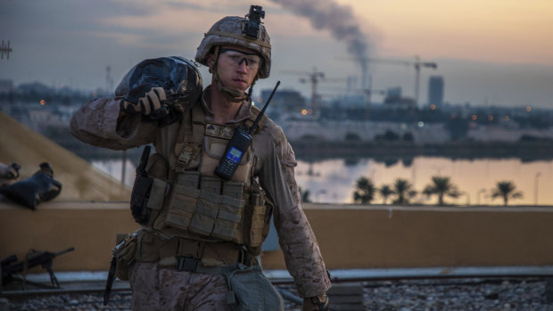 A US Marine carries a sand bag during the reinforcement of the US embassy compound in Baghdad, Iraq, in January. 