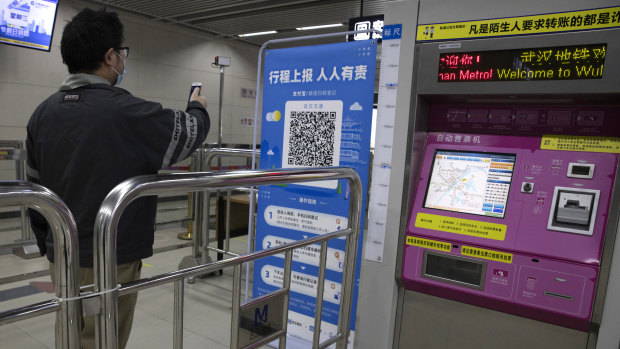 A commuter in Wuhan scans his health pass for the all-clear to ride the metro system.