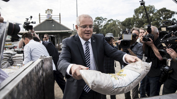 Prime Minister Scott Morrison moves some mulch at Daisy’s Garden Supplies in Ringwood on Monday.