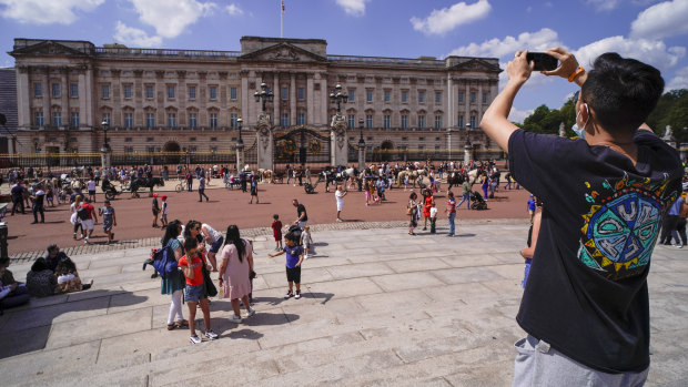 A man takes a picture of Buckingham Palace in London. The pandemic meant less revenue from tourists for the royal coffers.