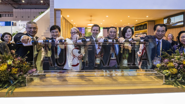Happier times: Trade Minister Simon Birmingham and former Australian ambassador to China Jan Adams pour wine into an Australia sign at the China International Import Expo in Shanghai in 2017.