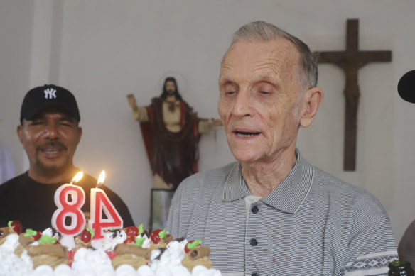 Now-defrocked Catholic priest Richard Daschbach, centre, is presented a cake during his 84th birthday in Dili in January. 