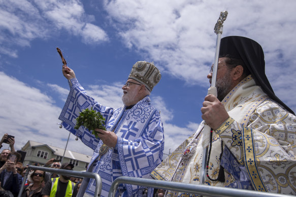 Greek Orthodox bishop Ezekiel (left) addresses the crowd on Princes Pier.