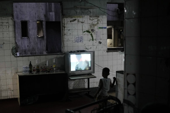 A boy watches a movie in a building occupied by squatters in Rio de Janeiro, Brazil on Friday. The election will be decided by tens of millions of poor people, and they look set to eject incumbent Jair Bolsonaro from office.