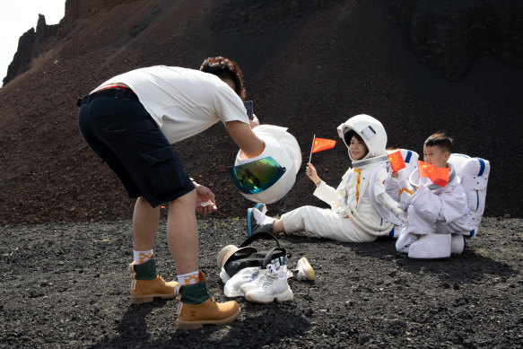 Patriotic tourists dress up as astronauts to watch the rocket launch in Hainan. 