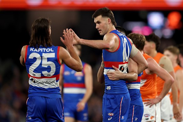 Sam Darcy of the Bulldogs is congratulated by Caleb Poulter after kicking a goal.