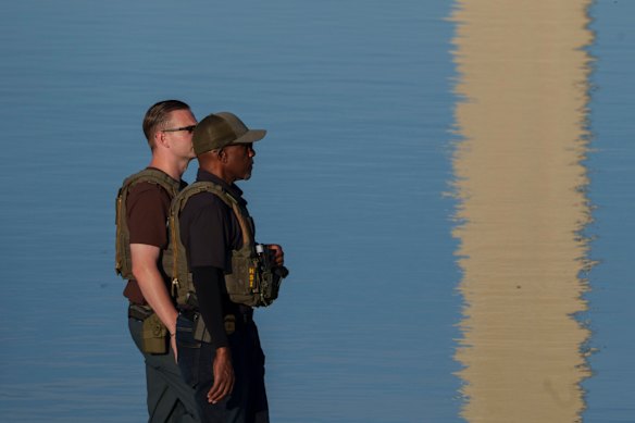 Federal law enforcement officers walk along the pool edge on the weekend.